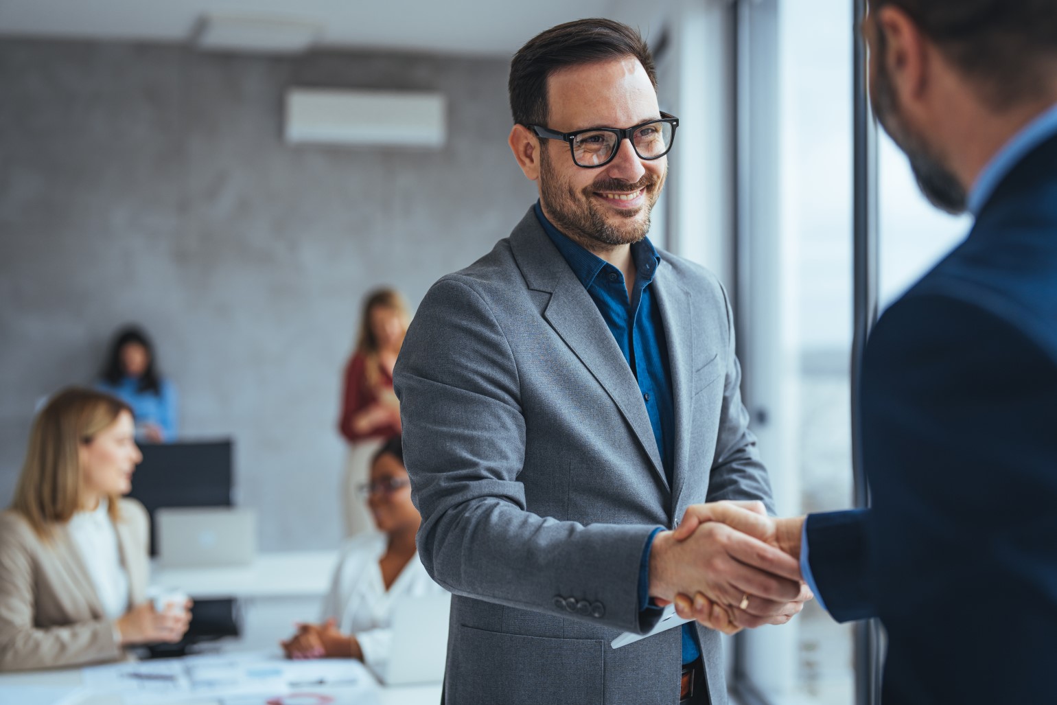 Portrait of cheerful young manager handshake with new employee